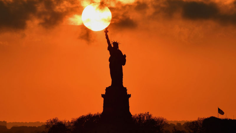 The sun sets behind the Statue of Liberty on June 11, 2020 in New York City. (Photo / RSS)