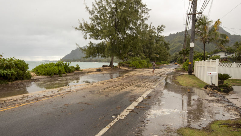 Sand and debris is left on Kamehameha Highway from high surf generated by Hurricane Douglas, Sunday, July 26, 2020, in Hauula, Hawaii. Hurricane Douglas came within razor thin distance of the Hawaiian Islands but spared the state the worst of the strong winds, storm surge and flooding officials had warned about. (AP Photo/RSS)
