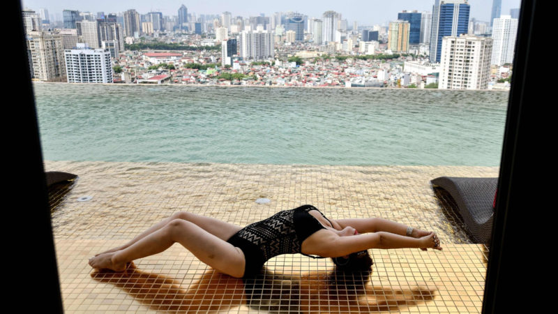 A guest poses for photographs at the infinity pool of the newly-inaugurated Dolce Hanoi Golden Lake hotel, the world's first gold-plated hotel, in Hanoi on July 2, 2020. (Photo /RSS)