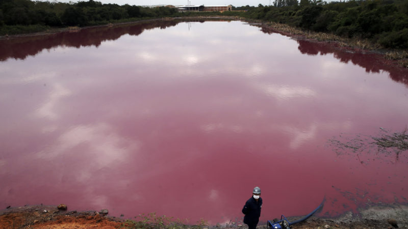 A worker stands by a pump as he extracts water for testing from Cerro Lagoon, which is pink and smells foul due to untreated waste allegedly dumped by the Waltrading S.A. tannery company, in Limpio, Paraguay, Wednesday, Sept. 2, 2020. The Environment Ministry, which is carrying out the testing, has proposed the tannery be closed due to the presence of heavy metals in the lagoon, like chromium, commonly used in the tannery process. (AP Photo/RSS)