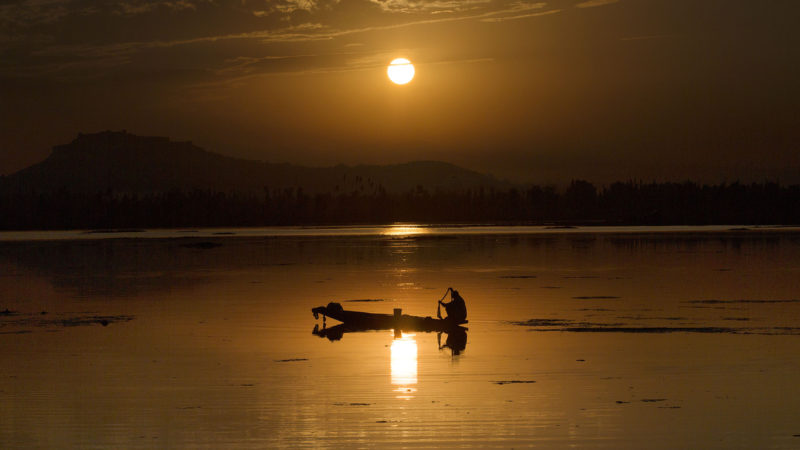 A fisherman pulls fishing net from the waters of Dal Lake as he catches fish during a sunset in Srinagar, the summer capital of Indian-controlled Kashmir, Sept. 12, 2020. (Photo/RSS)