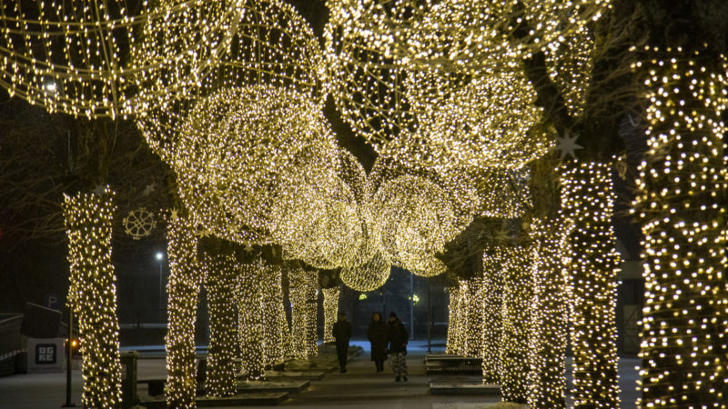 People walk under Christmas illuminations in Ogre, Latvia, Dec. 22, 2020. (Photo by Edijs Palens/RSS)