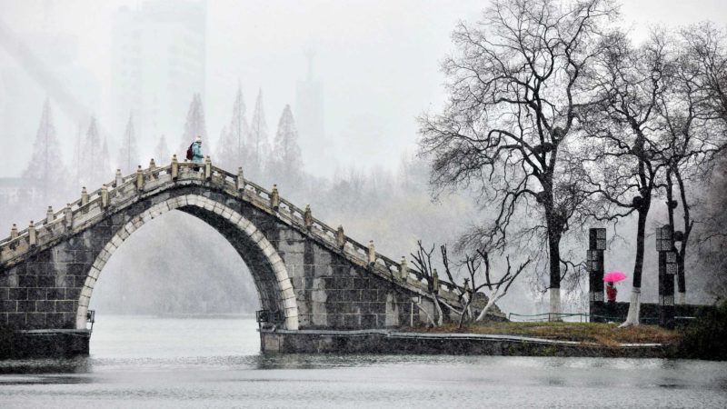 (201229) -- HEFEI, Dec. 29, 2020 (Xinhua) -- Visitors tour a park in snow in Hefei City of east China's Anhui Province, Dec. 29, 2020. China's meteorological authority on Tuesday renewed an orange alert, the second highest in a four-tier warning system, for a cold wave as a strong cold front has been sweeping across most parts of central and east China from Monday. (Xinhua/Han Xu)