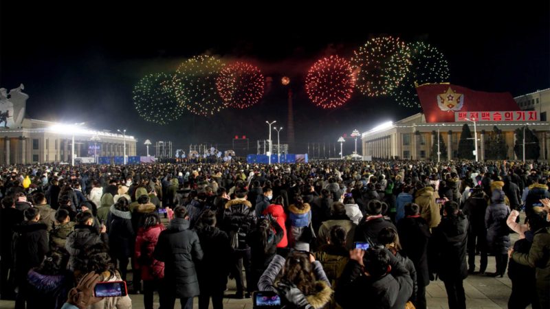 People watch a fireworks display during New Year celebrations at Kim Il Sung square in Pyongyang on January 1, 2021. (Photo by KIM Won Jin / AFP)