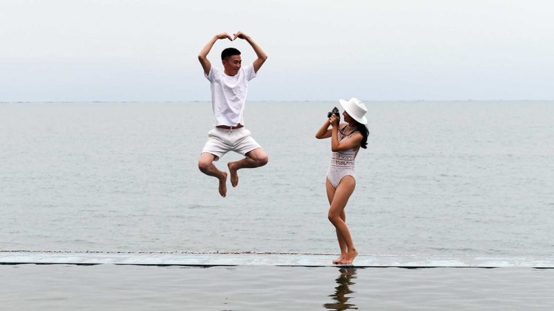 (210106) -- BEIJING, Jan. 6, 2021 (Xinhua) -- People pose for photos at Tianyahaijiao scenic spot, or the End of the Earth, in Sanya, south China's Hainan Province, Jan. 4, 2021. (Xinhua/Yang Guanyu)