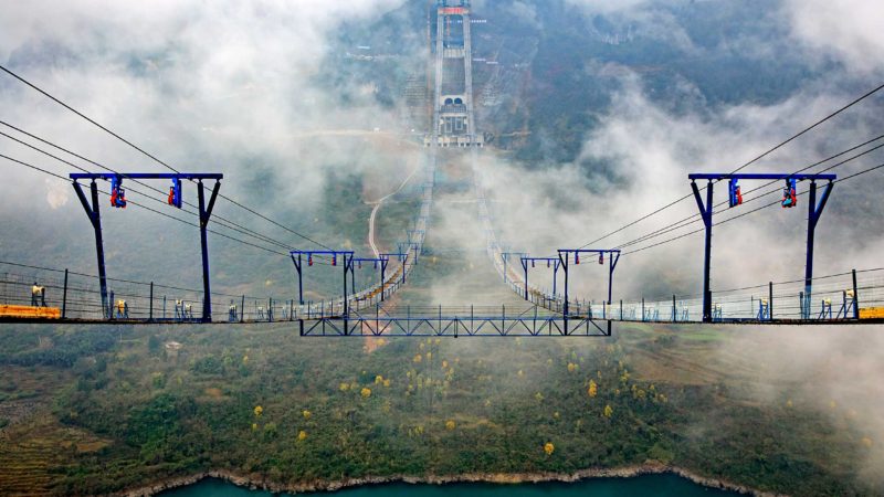 (210106) -- BEIJING, Jan. 6, 2021 (Xinhua) -- Photo taken on Jan. 5, 2021 shows the Kaizhou Lake grand bridge under construction in southwest China's Guizhou Province. The Kaizhou Lake grand bridge is part of the Weng'an-Kaiyang expressway. With a main span of 1,100 meters, the bridge is 1,257 meters in length and one of its main towers is 139 meters in height. (Xinhua/Liu Xu)