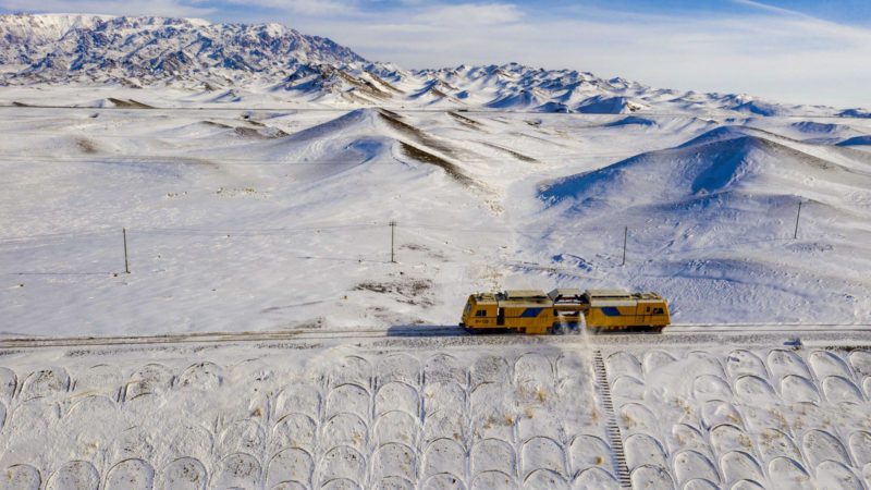 (210125) -- BEIJING, Jan. 25, 2021 (Xinhua) -- Aerial photo taken on Jan. 21, 2021 shows a railway track snow removing machine in operation in Maytas windy area along the Karamay-Tacheng railway, in northwest China's Xinjiang Uygur Autonomous Region. Maytas, dubbed "Hell of Wind," is a wild area where the Karamay-Tacheng railway trunk line in Xinjiang runs through. It is also a place where the Tiechanggou repairing team under the China Railway Urumqi Bureau Group Co., Ltd. is on the watch 24 hours a day to ensure safe operation of all trains passing by. (Xinhua/Hu Huhu)