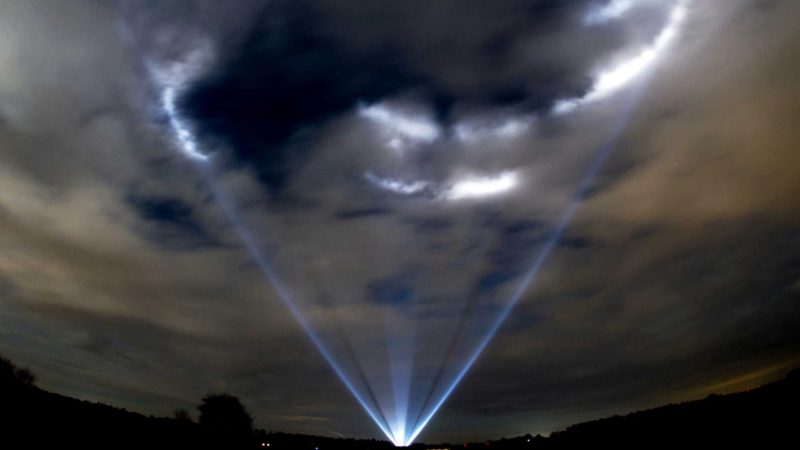 In this photo made with a fisheye lens, lights near the district of Sandkrug shine onto the clouds in Hatten, Lower Saxony, Germany on Thursday, Dec. 31, 2020. Festival organizer Jan Meiners set up powerful spotlights at four locations to celebrate New Year's Eve. (Hauke-Christian Dittrich/dpa via AP)