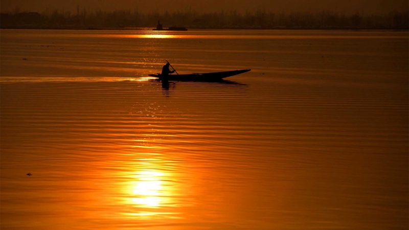 A man rows a boat at Dal Lake during sunset in Srinagar, the summer capital of Indian-controlled Kashmir, Feb. 7, 2021. (Xinhua/Javed Dar)