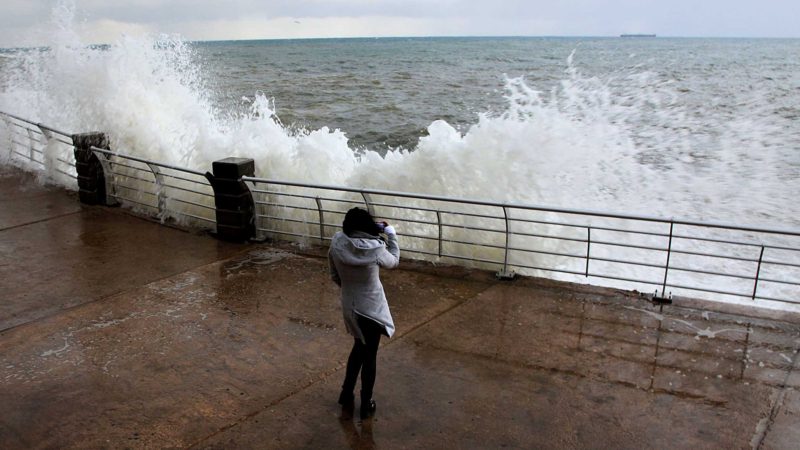 (210218) -- BEIRUT, Feb. 18, 2021 (Xinhua) -- A woman takes photos at the coast of Beirut, Lebanon on Feb. 17, 2021. Storm Joyce hit late Tuesday in Lebanon. (Xinhua/Liu Zongya)