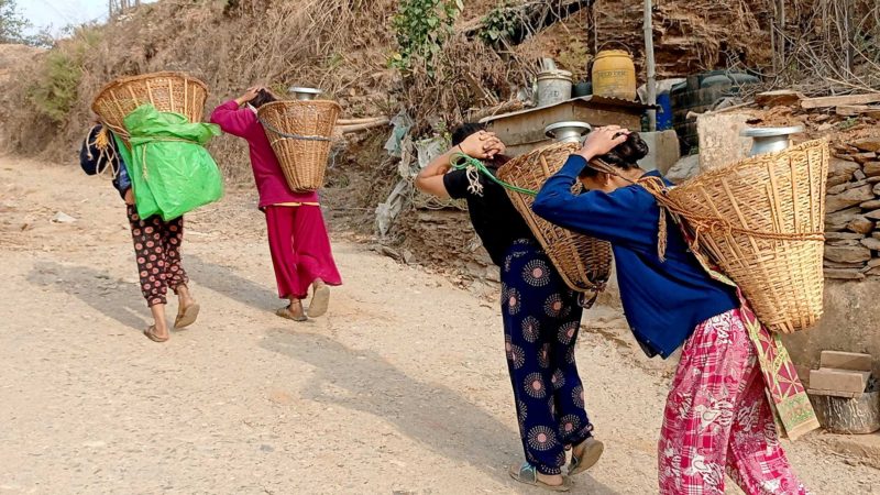 खानेपानीको समस्याका कारण तनहुँको घिरिङ गाउँपालिका–५ भगवतीपुरका महिला डोकोमा पानी बोकेर घरतर्फ जाँदै । तस्बिर : कृष्ण न्यौपाने/रासस