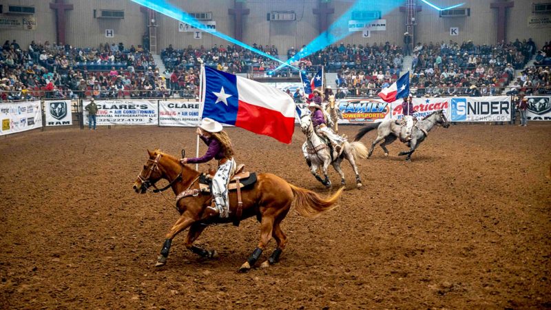 Riders carry the Texas state flag during the opening ceremony of the San Angelo Stock Show and Rodeo, April 16, 2021 in San Angelo, Texas. - The first night of the rodeo saw a sold out crowd, the first rodeo event that took place with no restrictions in San Angelo since the beginning of the pandemic. (Photo by Sergio FLORES / AFP)