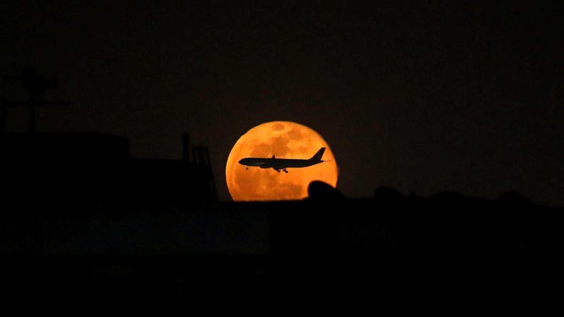 (210427) -- CAIRO, April 27, 2021 (Xinhua) -- A plane is seen flying across the super moon over Cairo, Egypt, on April 27, 2021. (Xinhua/Ahmed Gomaa)