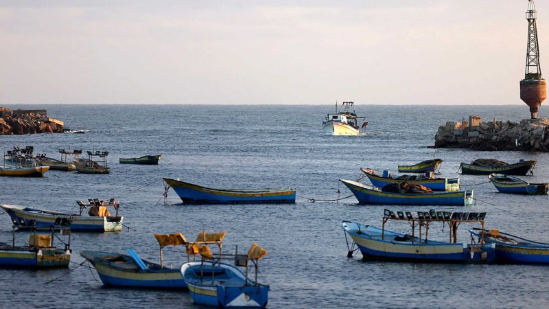 A Palestinian boat returns to port past idle vessels moored at Gaza City's main fishing harbour, on May 24, 2021, as Israeli security forces only allowed a limited number of vessels to return to sea following a ceasefire in the recent conflict. (Photo by Emmanuel DUNAND / AFP)