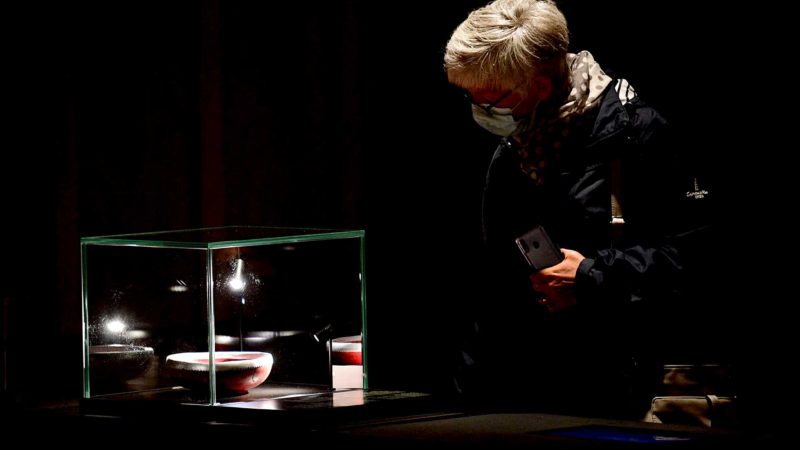 A visitor looks at a pottery belonging to St Waldebert, displayed at the Ecclesia exhibition space in Luxeuil-les-bains, eastern France, on May 26, 2021. - In the heart of the medieval city of Luxeuil-les-Bains, 150 sarcophagi from one of the most important Merovingian sites in Europe are exhibited at Ecclesia museographic site. (Photo by SEBASTIEN BOZON / AFP)