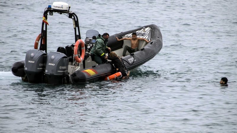 A Guardia Civil officer rescues people from the water who try to arrive into the Spanish territory next to the border of Morocco and Spain, at the Spanish enclave of Ceuta, on Tuesday, May 18, 2021. Ceuta, a Spanish city of 85,000 in northern Africa, faces a humanitarian crisis after thousands of Moroccans took advantage of relaxed border control in their country to swim or paddle in inflatable boats into European soil. Around 6,000 people had crossed by Tuesday morning since the first arrivals began in the early hours of Monday, including 1,500 who are presumed to be teenagers. (AP Photo/Javier Fergo)