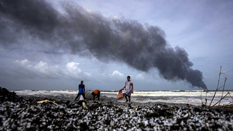 Impoverished Sri Lankans salvage wreckage washed off to the shore from the burning Singaporean ship MV X-Press Pearl which is anchored off Colombo port at Kapungoda, outskirts of Colombo, Sri Lanka, Wednesday, May 26, 2021. A fire on the container ship carrying chemicals raged off Sri Lanka for a sixth day Wednesday and India sent vessels to help douse the blaze, officials said. (AP Photo/Eranga Jayawardena)