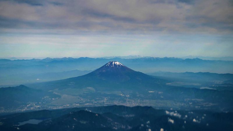 This picture taken on June 11, 2021 shows Mount Fuji, Japan's highest mountain at 3,776 meters (12,388 feet), seen from the window of a passenger aircraft en route to Naha. (Photo by Charly TRIBALLEAU / AFP)