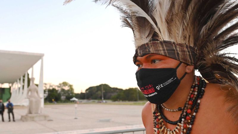 An indigenous man protests against a controversial land reform bill, outside the Supreme Court in Brasilia on June 29, 2021. - On June 30, the Supreme Court reviews a controversial bill that would change the regulations establishing protected indigenous lands. Indigenous rights groups warn the bill would pave the way for things such as mining, hydroelectric dams and road construction on previously protected reserves. (Photo by EVARISTO SA / AFP)