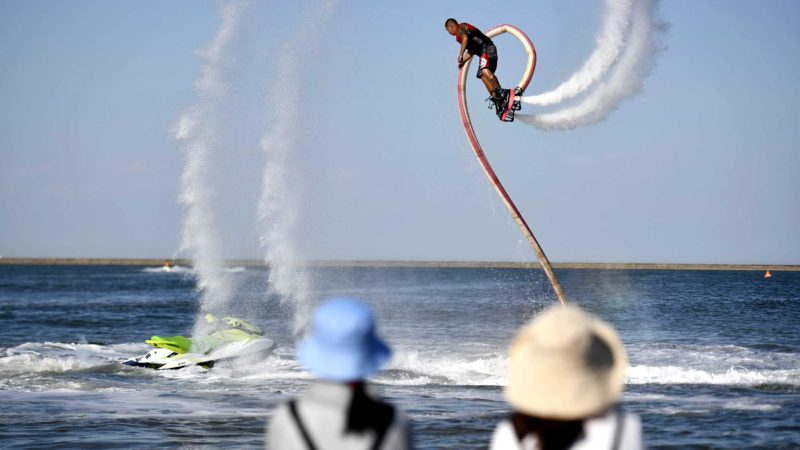 (210607) -- TIANJIN, June 7, 2021 (Xinhua) -- Tourists watch a stunt performance at an artificial beach resort at Dongjiang Port in the Binhai New Area of north China's Tianjin, June 5, 2021.
 Tianjin in north China boasts rich biodiversity along a 153-km coastline made up of muddy tidal flats.
 Over the years, the city has worked on pollution control and shoreline management of the Bohai Sea to restore its coastal wetlands, while stricter measures on land reclamation have been implemented.
 In 2020, 70.4 percent of Tianjin's offshore waters achieved sound quality under a three-year action plan to battle water pollution.
 Now the coastline of Tianjin is dotted with parks, wetlands, and artificial beaches which enable people to reach out to the sea with ease. (Xinhua/Zhao Zishuo)