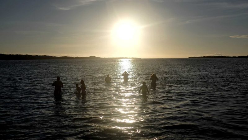 People sit at the Key 360 of Morrocoy National Park, Falcon state, Venezuela, Saturday, June 26, 2021. "Full Day" packaged trips include transportation, meals and recreational games, which have become popular during the flexible quarantine measures related to the pandemic, permitting certain businesses to operate for a limited period. (AP Photo/Matias Delacroix)