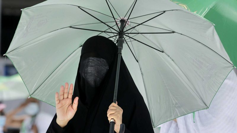 A Muslim pilgrim prays in front of the the Kaaba, the cubic building at the Grand Mosque, as she wears a mask and keeps social distancing, a day before the annual hajj pilgrimage, Saturday, July 17, 2021. The pilgrimage to Mecca required once in a lifetime of every Muslim who can afford it and is physically able to make it, used to draw more than 2 million people. But for a second straight year it has been curtailed due to the coronavirus with only vaccinated people in Saudi Arabia able to participate. (AP Photo/Amr Nabil)