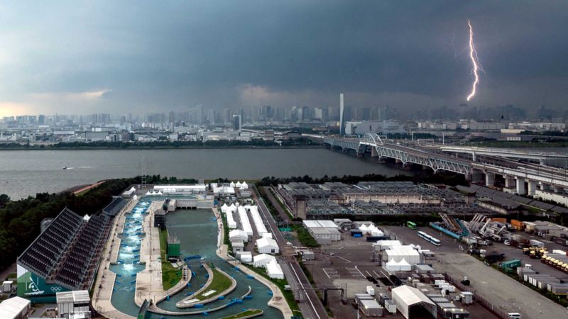 TOPSHOT - A bolt of lightning is seen in the background past the Kasai Canoe Slalom Centre, the main venue for canoe slalom during the Tokyo 2020 Olympic games, in Tokyo on July 11, 2021. (Photo by Philip FONG / AFP)