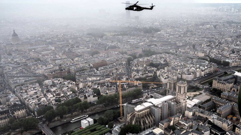 An NH90 "CAIMAN" helicopter flies over the Notre-Dame de Paris Cathedral on the "Ile de la Cite" island in the Seine river during a practice session prior to July 14's Bastille Day Parade in Paris on July 12, 2021. (Photo by BERTRAND GUAY / AFP)