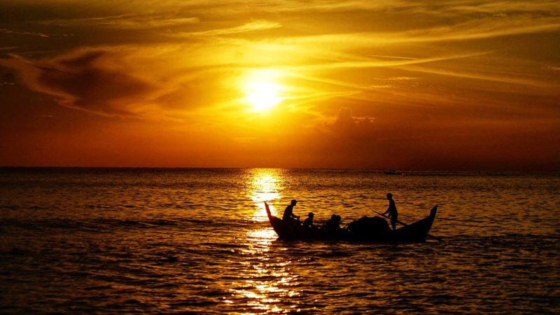 Fishermen take their boat out to sea at dawn in Lhokseumawe, Aceh on July 27, 2021. (Photo by Azwar Ipank / AFP)