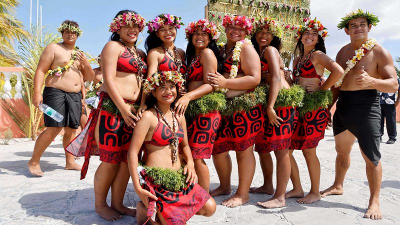 Local dancers wait to welcome French President Emmanuel Macron (not pictured) upon his arrival in Manihi atoll, in the Tuamotu Archipelago, French Polynesia on July 26, 2021. (Photo by Ludovic MARIN / AFP)