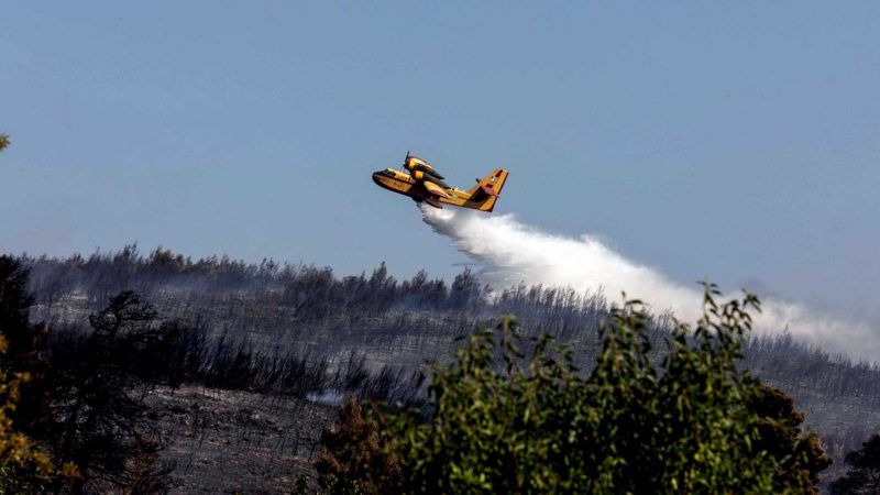 (210727) -- ATTICA (GREECE), July 27, 2021 (Xinhua) -- A firefighting aircraft douses a wildfire in the village of Stamata in the eastern Attica region, Greece, on July 27, 2021. Greek firemen were battling on Tuesday a major wildfire fanned by strong winds in the villages of Stamata and Rodopoli in the eastern Attica region. (Photo by Lefteris Partsalis/Xinhua)