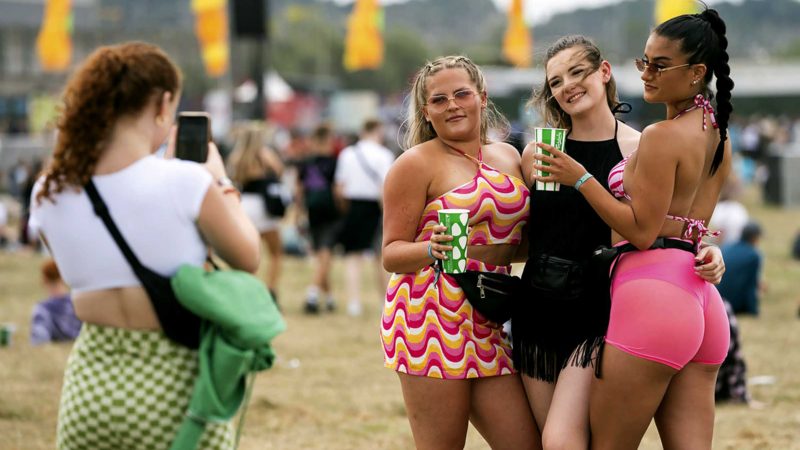 Members of the public take a picture in front of the Main Stage West as they attend the Reading Music Festival, England, Saturday, Aug. 28, 2021. (AP Photo/Scott Garfitt)