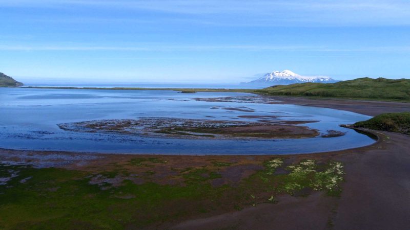 This photograph taken July 8, 2021, shows Clam Lagoon, located on the northeast side of Adak Island, Alaska, and the Great Sitkin Volcano in the distance. The lagoon’s sprawling mudflats attract adventurous bird watchers from around the globe. (Nicole Evatt via AP)