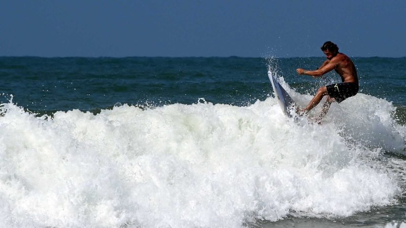 (210817) -- LADISPOLI (ITALY), Aug. 17, 2021 (Xinhua) -- A man surfs the waves off Ladispoli in Lazio, Italy, on Aug. 17, 2021. (Photo by Alberto Lingria/Xinhua)