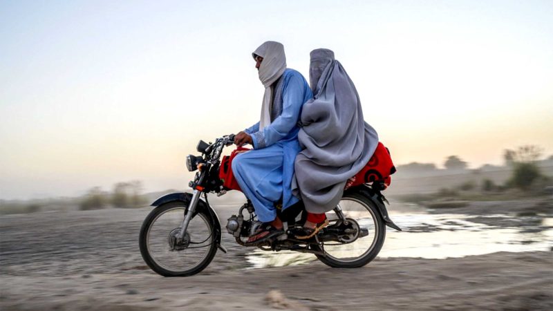 In this picture taken on September 23, 2021, a man and a woman travel on a motorcycle in Kandahar. (Photo by Bulent KILIC / AFP)