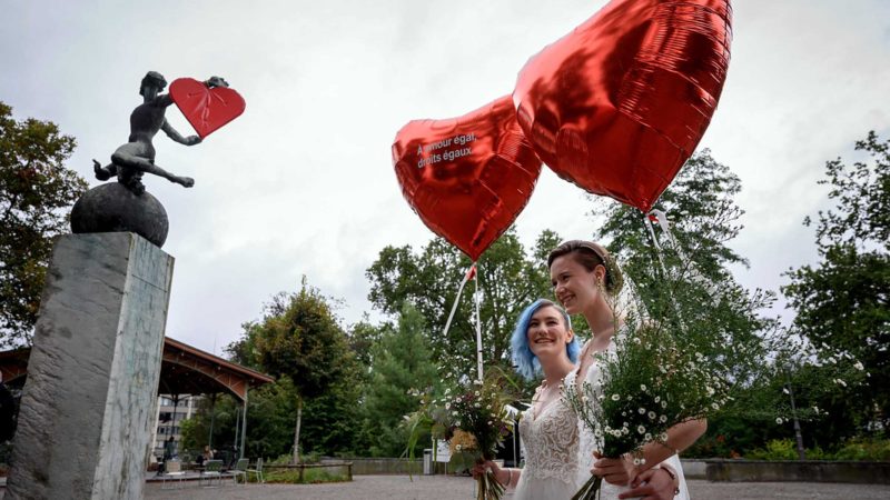 A couple arrive to a photo event during a nationwide referendum's day on same-sex marriage, in Swiss capital Bern on September 26, 2021. - Swiss voters have approved the government's plan to introduce same-sex marriage, according to the first projections following September 26 referendum triggered by opponents of the move. Shortly after the polls closed at noon market researchers GFS Bern, who conducted the main polling throughout the campaign, projected that the "yes" vote was heading for victory, which would bring the Alpine nation into line with most of western Europe. (Photo by Fabrice COFFRINI / AFP)