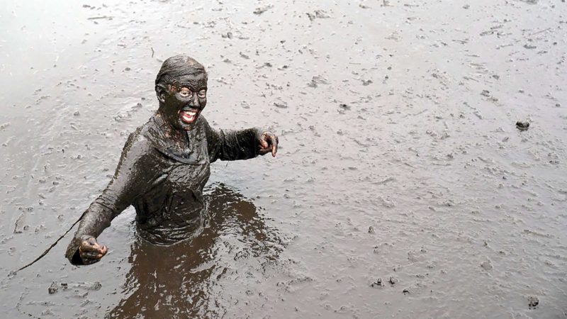 A competitor is covered in mud during a Tough Mudder event at Cholmondeley Castle Gardens in Malpas, Cheshire, Saturday Sept. 4, 2021. (Jacob King/PA via AP)