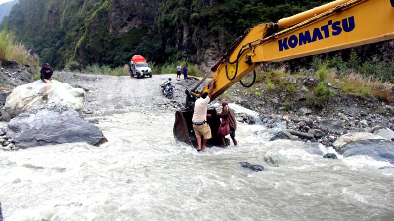 बेनी–जोमसोम–कोरला सडकअन्तर्गत म्याग्दीको रघुगङ्गा गाउँपालिका–१स्थित बेगखोलामा बाढी आएपछि स्काभेटरको बकेटमा बसेर खोला तर्दै यात्रु । तस्वीर : सन्तोष गौतम/ रासस