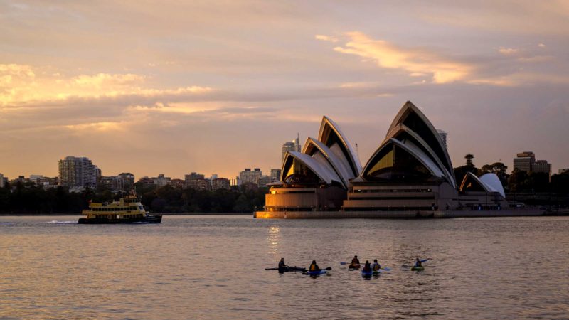 Kayakers sit in Sydney harbour as the sun rises in Sydney Tuesday, Oct. 19, 2021. (AP Photo/Mark Baker)