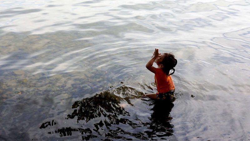 A girl enjoys a bath at Izabal lake in El Estor indigenous municipality, during the state of siege after protests against the Compañia Guatemalteca de Niquel -a subsidiary of Solway Investment Group-, in northeast Guatemala, on October 24, 2021. - Guatemalan President Alejandro Giammattei declared a state of siege -in force for 30 days- in El Estor, a day after the police clashed with indigenous protesting against the mining company, which they accuse of causing environmental damage. The incident left four officers wounded by bullets. (Photo by Johan ORDONEZ / AFP)