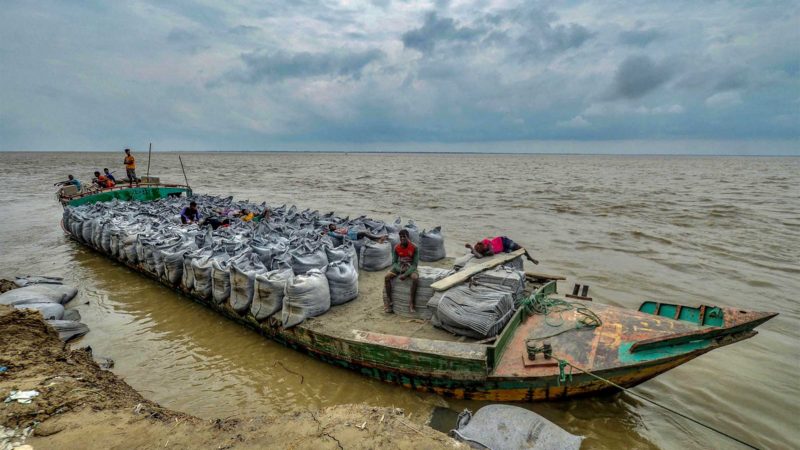 In this picture taken on September 20, 2021, a boat carrying geo-textiles bags used to prevent erosion anchors on the banks of river Padma in Manikgonj. - Bangladesh, a low-lying nation of criss-crossing muddy rivers at the top of the Bay of Bengal, has long been battered by nature. (Photo by Munir Uz zaman / AFP) / TO GO WITH Climate-UN-COP26-Bangladesh-refugee,PROFILE by Shafiqul ALAM