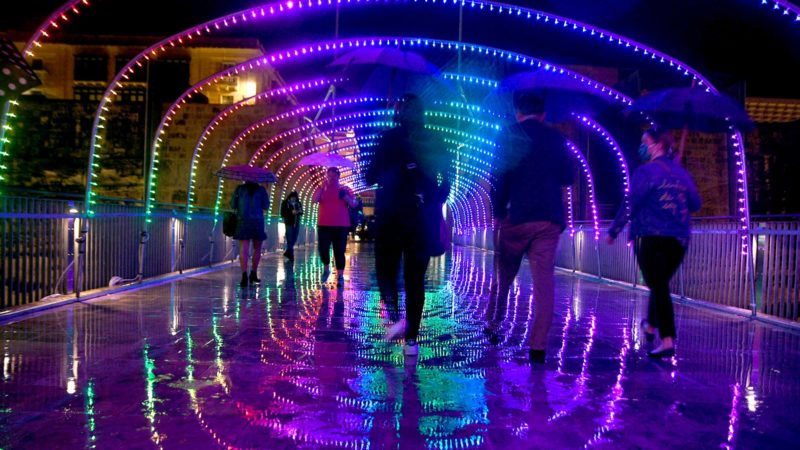 (211013) -- VALLETTA, Oct. 13, 2021 (Xinhua) -- People walk on a light-decorated street in Valletta, capital of Malta, on Oct. 13, 2021. Pedestrian spaces in Valletta's streets and squares are adorned with illuminations for the initiative Light Up Valletta. (Photo by Jonathan Borg/Xinhua)