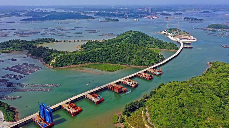 (211005) -- QINZHOU, Oct. 5, 2021 (Xinhua) -- Aerial photo taken on Oct. 4, 2021 shows the construction site of the Longmen Bridge in Qinzhou City, south China's Guangxi Zhuang Autonomous Region. Located in the city of Qinzhou, the Longmen Bridge, a cross-sea bridge connecting coastal cities along the Beibu Gulf of Guangxi, will stretch roughly 7.6 km, with the main bridge measuring 1,198 meters in length. (Xinhua/Zhou Hua)