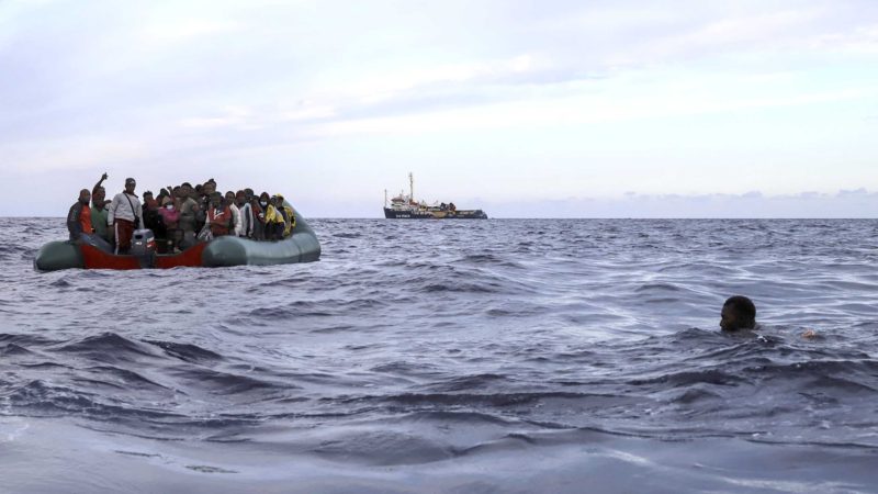 A migrant who was aboard a precarious rubber boat with others jumps to the water as they are rescued by a team of the Sea Watch-3, around 35 miles away from Libya, in Libyan SAR zone, Monday, Oct. 18, 2021. (AP Photo/Valeria Mongelli)