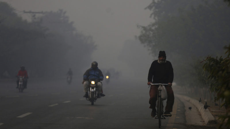 Motorcyclists and cyclist move along a road as smog envelops area of Lahore, Pakistan, Sunday, Nov. 28, 2021. People of Lahore and neighboring areas are suffering from increased respiratory problems due to the poor air quality hanging over the region. (AP Photo/K.M. Chaudary)