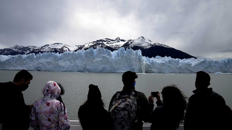 Tourists look at the Perito Moreno Glacier from a boat at Los Glaciares National Park near El Calafate, Argentina, Tuesday, Nov. 2, 2021. World leaders are gathered in Scotland at a United Nations climate summit, known as COP26, to push nations to ratchet up their efforts to curb climate change. Experts say the amount of energy unleashed by planetary warming could melt much of the planet's ice, raise global sea levels and increase extreme weather events. (AP Photo/Natacha Pisarenko)