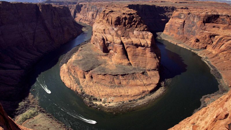 FILE - Water levels at the Colorado River's Horseshoe Bend begin to rise along the beaches just hours after the Glen Canyon Dam jet tubes began releasing water, March 5, 2008, in Page, Ariz. The U.S. Bureau of Reclamation decided against sending water rushing through the Grand Canyon this fall to redeposit sediment because of persistent drought. Agency officials said opening the bypass tubes at the Glen Canyon Dam would have reduced the elevation of Lake Powell at a time when it's at historic lows. (AP Photo/Matt York, File)